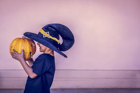 Halloween 2019. Little boy holding carved halloween pumpkin - Jack O'Lanterns at outdoors. Family preparations to Halloween holiday.の写真素材