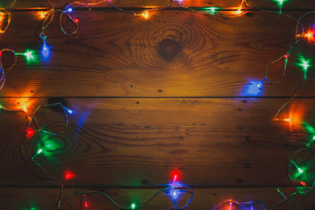 Christmas decorative lights. Christmas garland lights on wood. Colorful Xmas light bulbs on wooden...