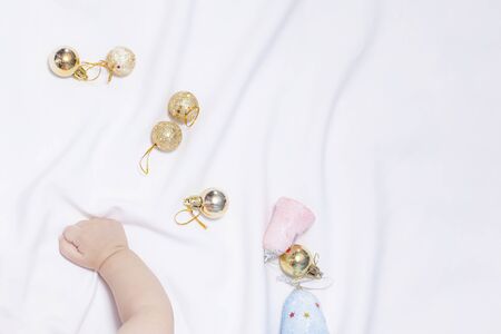 Baby boy playing with Christmas tree balls and toys, Copy space. Cute and adorable baby playing at his bed. Christmas morning. Winter holidays. Family celebration.の写真素材