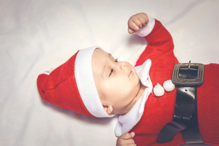Merry christmas from Little Santa. 6-9 months old baby boy worn in costume of Santa Claus. Copy...