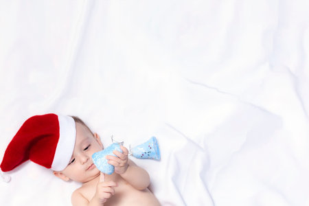 9-month baby boy with Santa Claus hat. Christmas morning. Little kid playing. Adorable baby boy with...