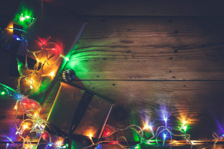 Christmas decorative lights. Christmas garland lights on wood. Colorful Xmas light bulbs on wooden...