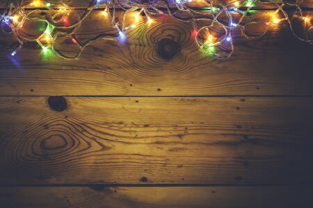 Christmas decorative lights. Christmas garland lights on wood. Colorful Xmas light bulbs on wooden table with copy space. Christmas mood. Free space for text or adの写真素材