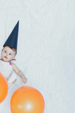 First birthday. Little baby girl celebrating birthday. 1 year old kid playing with paper decorative...
