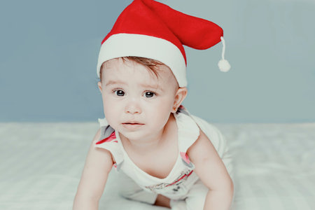 Little Santa. 1-year-old baby girl in Santa Claus hat. Merry Christmas. Adorable middle-eastern girl...