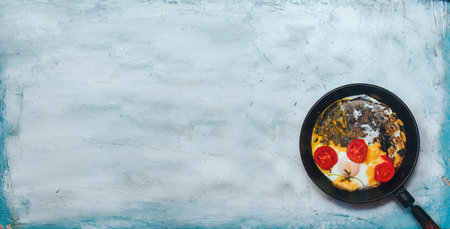 Breakfast with fried eggs and vegetables. Fried egg pan. Omelet in the frypan with fresh vegetables