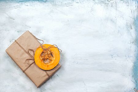 Holiday foods and gift box. Autumn, Fall, Halloween and Thanksgiving concept. Present box with sliced peace of pumpkin and fall leaves. Copy spaceの写真素材