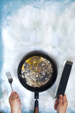 Female eating fried egg amelet on fry pan. Dirty fry pan breakfast, lunch or dinner. No more dieting. Can not stop eating. Unhealthy food. Dieting problemsの写真素材