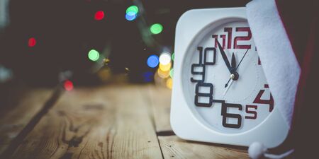 Christmas holiday eve. New year decor with bokeh lights. Magic Winter. Clock at midnight. Greeting new 2020 Year. Clock with blurry magic lights.の写真素材