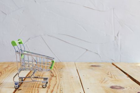 A miniature trolley shopping cart on wooden deskの写真素材