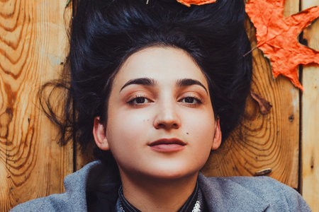 Autumn woman. Fall season concept. A portrait of lying on wooden floor woman. Young, beautiful and...