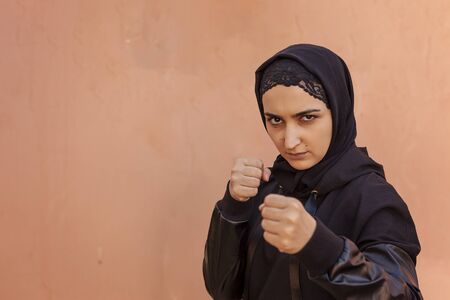 Muslim boxer woman in Islamic sportswear. Muslim fighter boxer posing doing exercises. Healthy lifestyle, sport in Islamic countries, women rights conceptsの写真素材