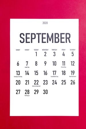 September 2020 calendar with holidays on red paper backgroundの写真素材