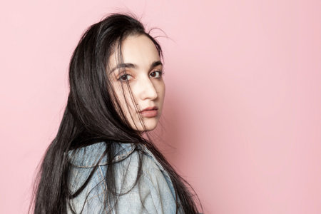 Portrait of happy middle-eastern female posing against a pink background. Studio portrait of a...