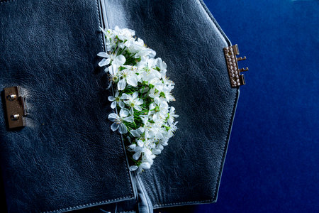 Cherry Blossom flowers in clutch purse . Beautiful Spring tree blossoms in leather handbag