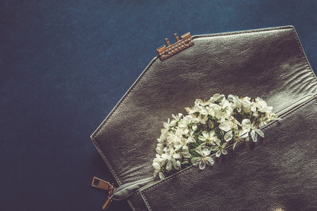 Cherry Blossom flowers in clutch purse . Beautiful Spring tree blossoms in leather handbag