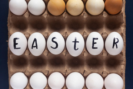 Easter festive eggs in carton with text. Easter text written on white eggs. Happy easter, spring...