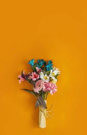 A bouquet of fresh spring flowers on the bright colored background. Top view of spring floral background with copy spaceの写真素材