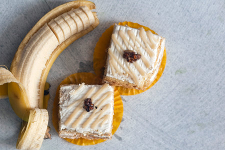 Pastry cream cake with banana and walnut on marble background.の写真素材