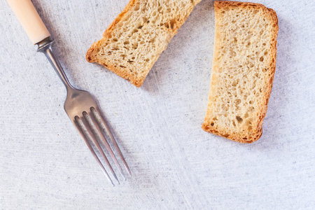 Tasty dietary bread with fork on stone background. Healthy food. Top view. Copy spaceの写真素材