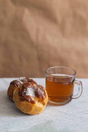 Two custard pastry cake with a cup of tea on marble background