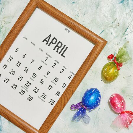 Monthly April 2020 calendar with colorful decorated Easter eggs. View from above. Top view. Easter holidays, festive, springtime conceptsの写真素材