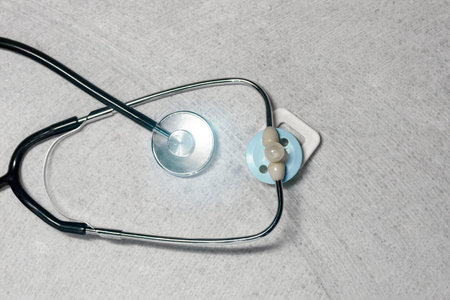 Stethoscope, phonendoscope and baby nipple on the marble. Top view