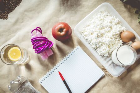 Diet planning. Meal plan. skipping rope and healthy food: a bottle of water, apple, cottage cheese.の写真素材