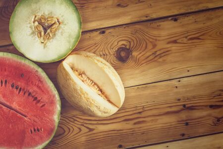 Sweet organic summer muskmelons and watermelon on the wooden background. Ripe melons on wood. View from above. Top view. Copy spaceの写真素材
