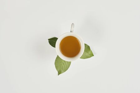 A cup of sweet green tea and leafs on the pure white backgroundの写真素材