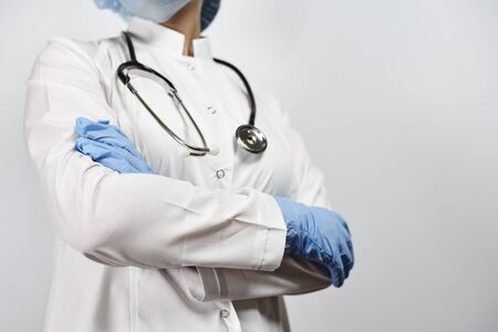 Cropped view of female doctor posing with stethoscope in uniform. Health care system worker in white uniform and surgical gloves. Medicine, Healthcare, online medical consulting conceptsの写真素材