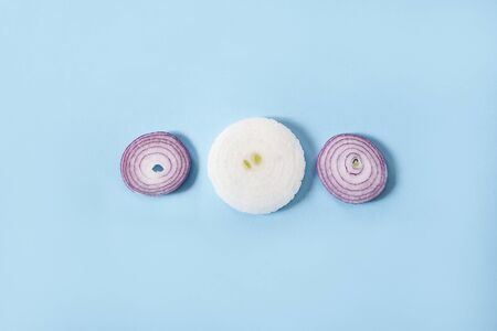 Onion rings on blue background. Fresh organic onion vegetable. Vegetarian backgroundの写真素材