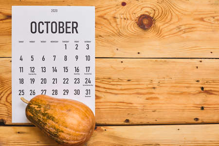 Simple 2020 October monthly calendar on the wooden desk with a pumpkinの写真素材