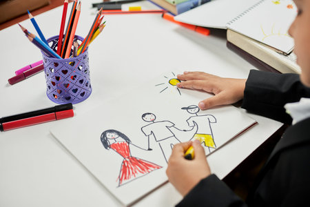 Family therapy. Schoolboy drawing family. Painting with colored marker. Drawing class. Homeschooling...