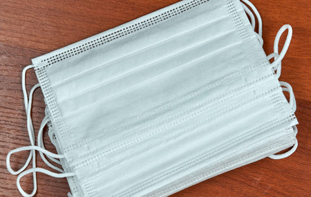 Pile of medical face masks on wooden background