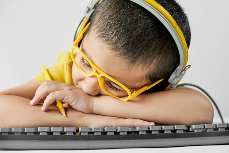 Boy looking tired of doing homework. Schoolboy sleeping in class