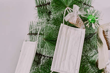 Christmas tree decorated with face masks and toys. Merry Christmas in coronavirus pandemic period. Celebrating Xmas in covid-19. Safe holiday celebrationの写真素材