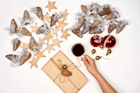 Xmas morning. Drinking coffee and preparing Christmas present. A cup of black coffee and Christmas festive ornaments on whiteの写真素材