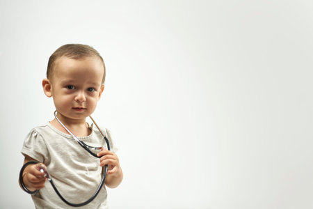 Baby boy with a stethoscope playing as he was a little doctor. 1-year-old baby boy in the medical...