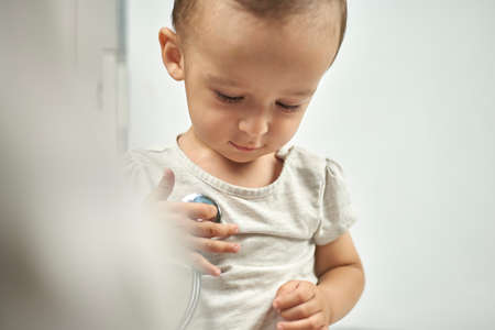 pediatrician listening to baby heartbeat. Physical examination of the 1-year-old baby boy. Well-baby exam. Regularly scheduled medical check-upの写真素材