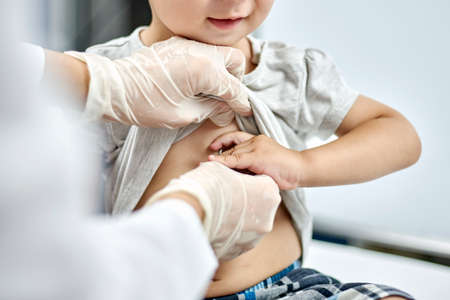 Doctor trying to listen to baby heartbeat. Physical examination of the 1-year-old baby boy. Well-baby exam. Regularly scheduled medical check-upの写真素材