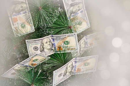 Financial Christmas tree. Festive Xmas tree decorated with hundred US dollars instead of Christmas ornamentsの写真素材