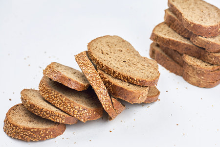 Pile of loaf bread slices on white fabric textile with copy space