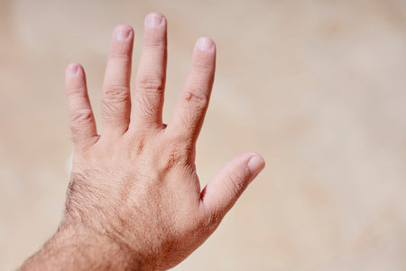 A man shocked with wrinkly and pruney skin of his hands after the bath, or being in water