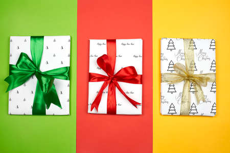 X-mas gift wrapped in paper with Christmas prints and tied with black ribbon. Christmas present box on white backgroundの写真素材