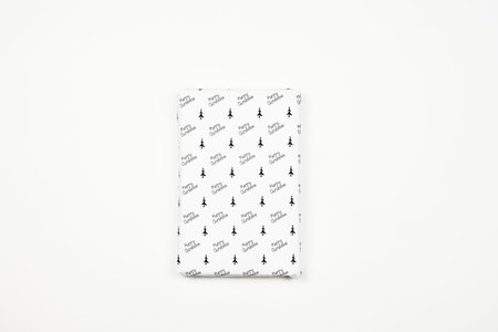 Xmas present wrapped in paper with festive prints. Christmas gift on white background. Homemade...