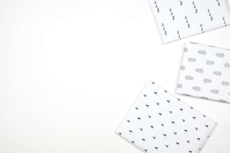 Xmas present wrapped in paper with festive prints. Christmas gift on white background. Homemade bright Christmas present boxの写真素材