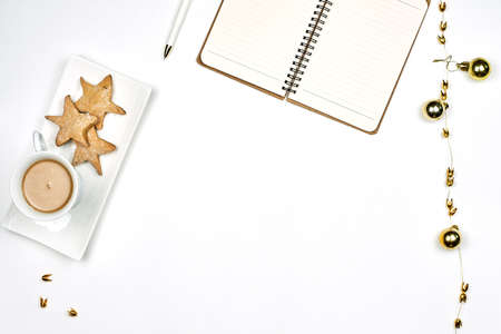 Having breakfast in Christmas morning. Drinking coffee with cookies at work. Bright working space with notepad, coffee mug and star shape cookiesの写真素材