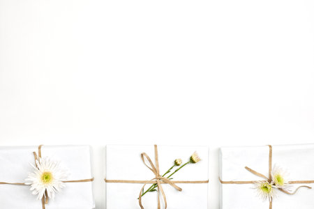 Spring gifts. Fresh spring flowers and gift boxes on white background. Giving a gift. Receiving a present with flowersの写真素材