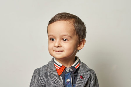 Funny portrait of a 2-years-old boy in a handmade elegant suit. A kid boy making a funny foolish...